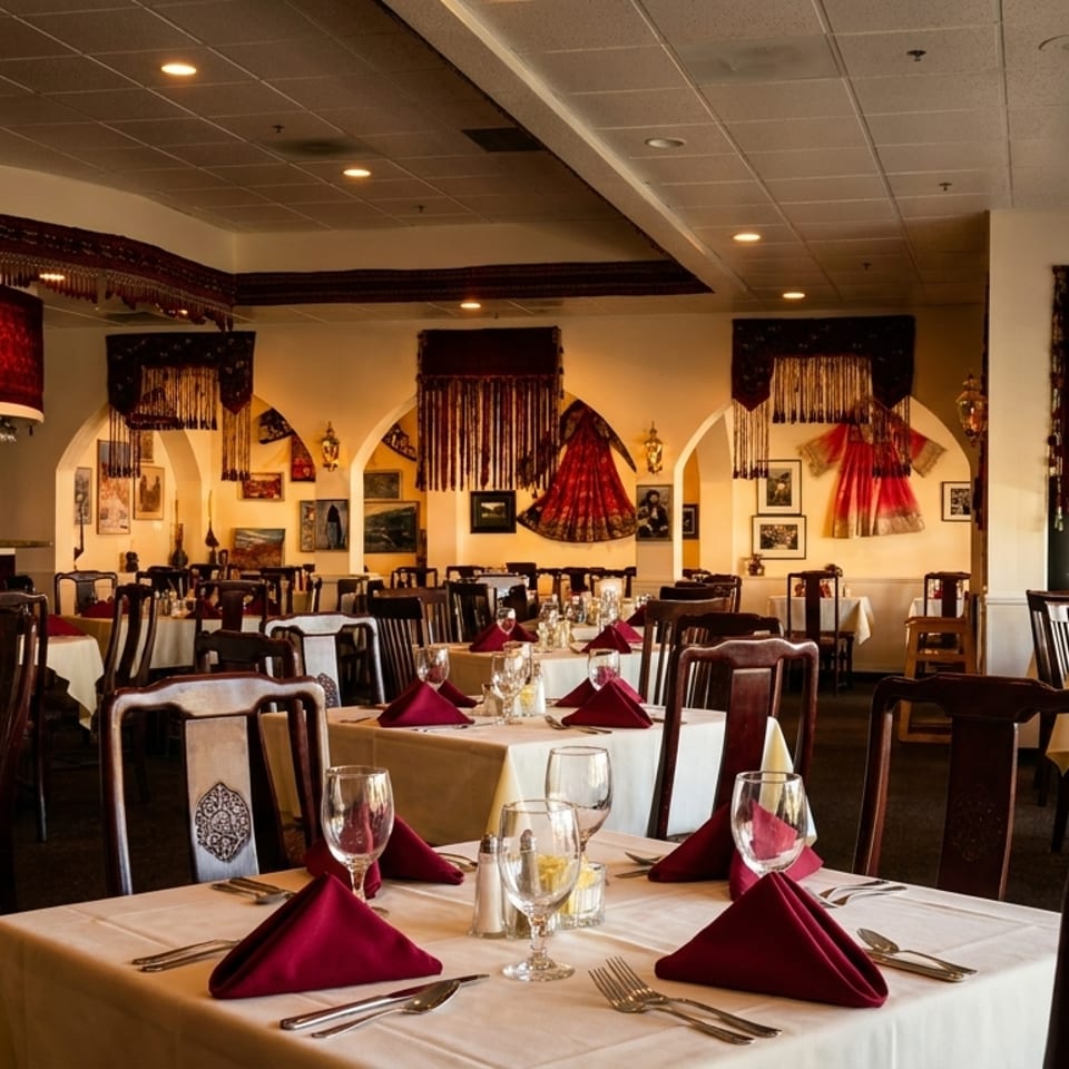 Elegant dining room with set tables, dark wood chairs, and decorative tapestries on the walls.